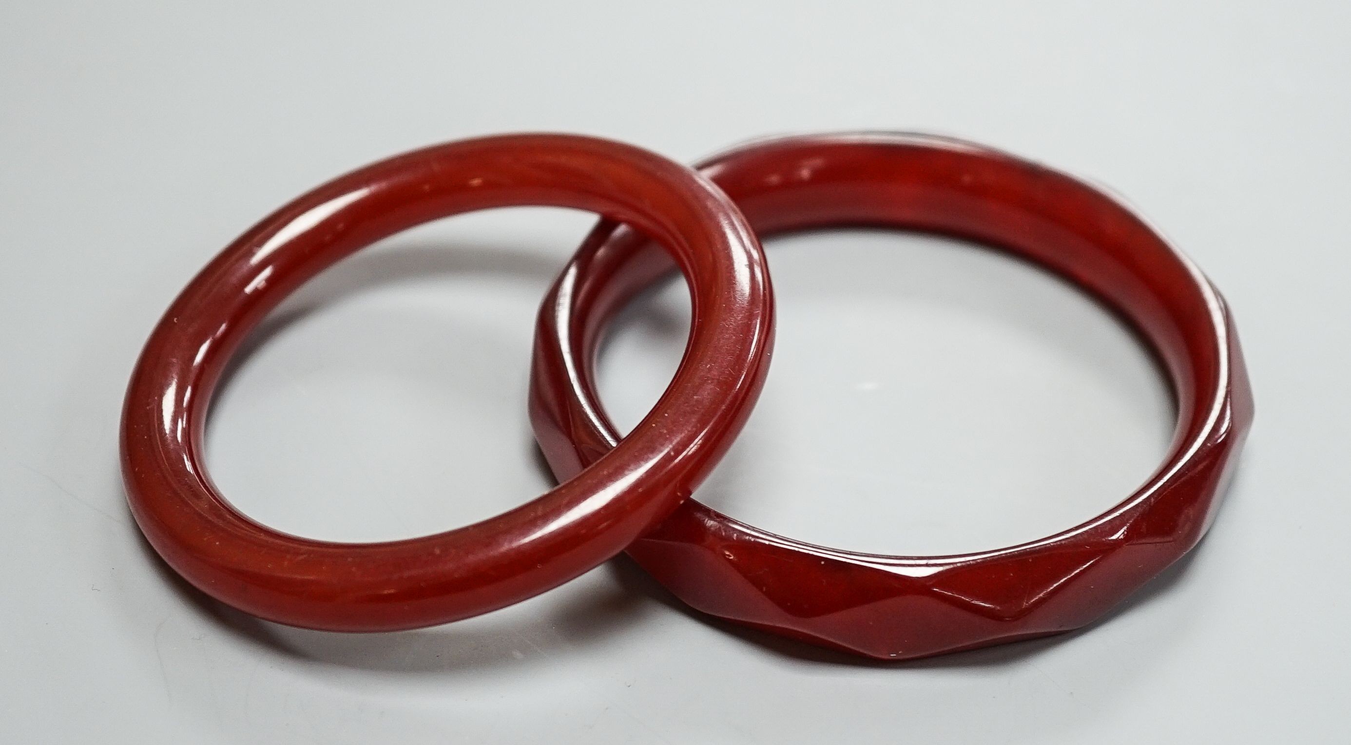 Two cherry amber bangles, gross weight 53 grams.